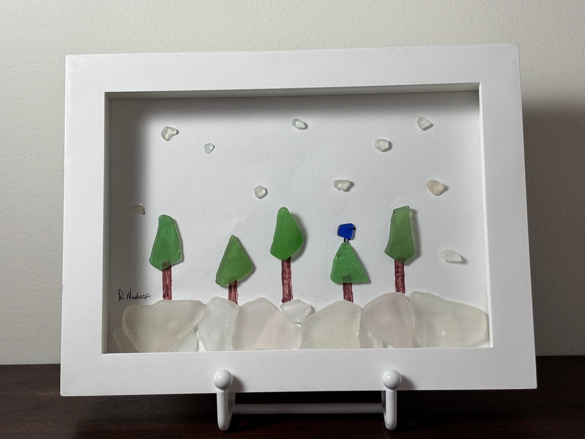 Blue jay in snowy forest made of sea glass