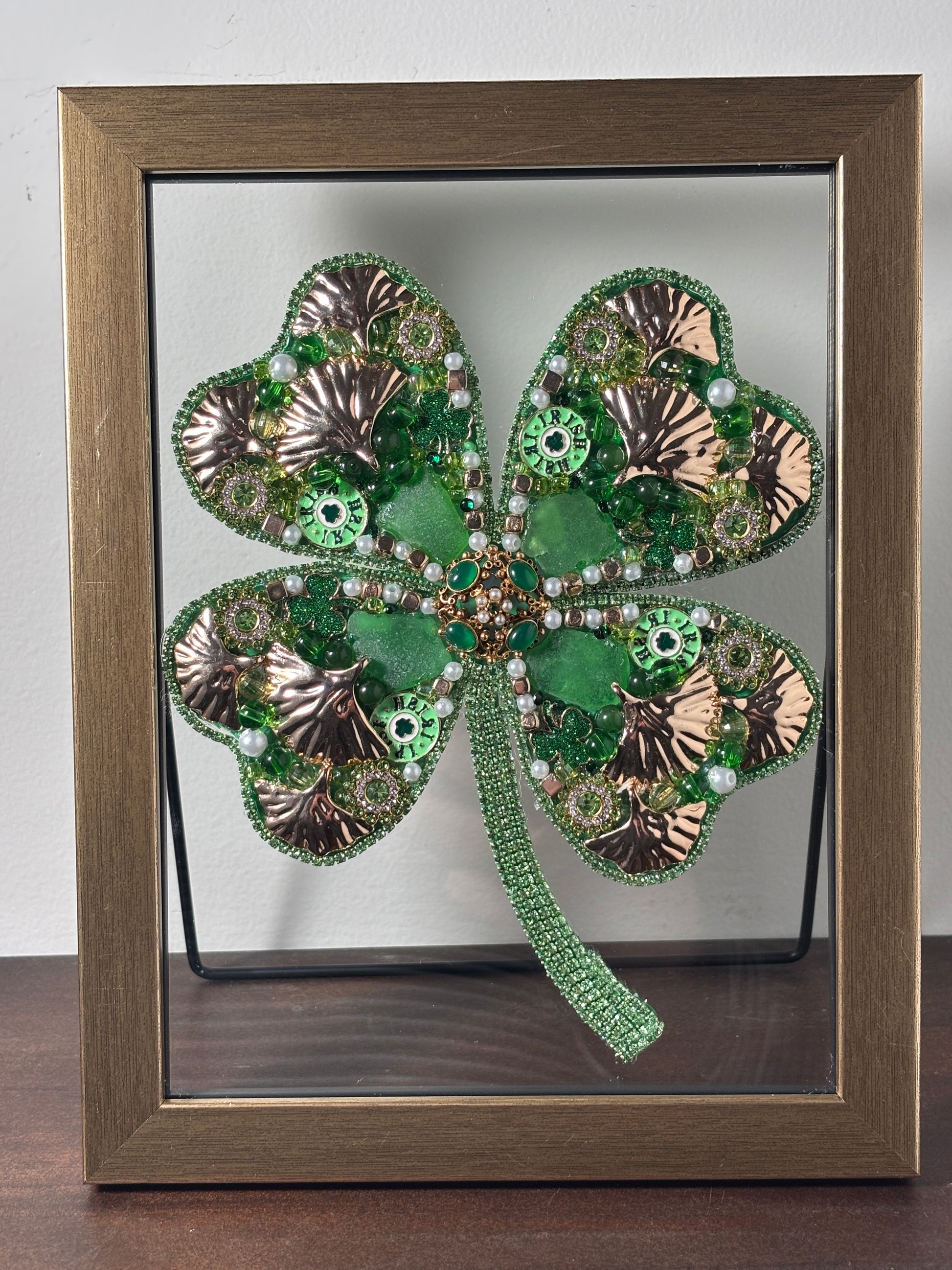 Decorative four-leaf clover with metallic accents and sea glass.